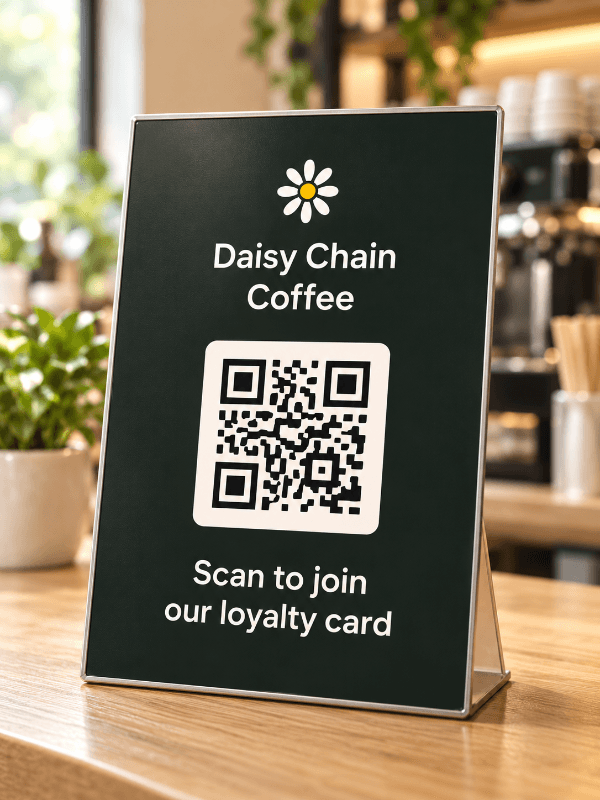 A Daisy Chain Coffee point-of-sale sign displaying a loyalty card QR code